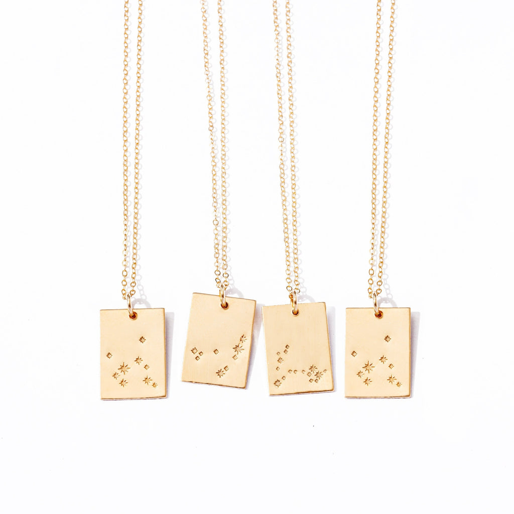 three gold necklaces with small stars on them